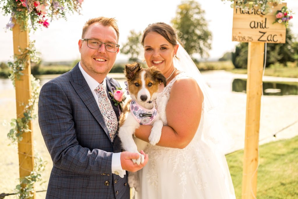 Couple posing with their dog in the gardens at Cheswell Grange
