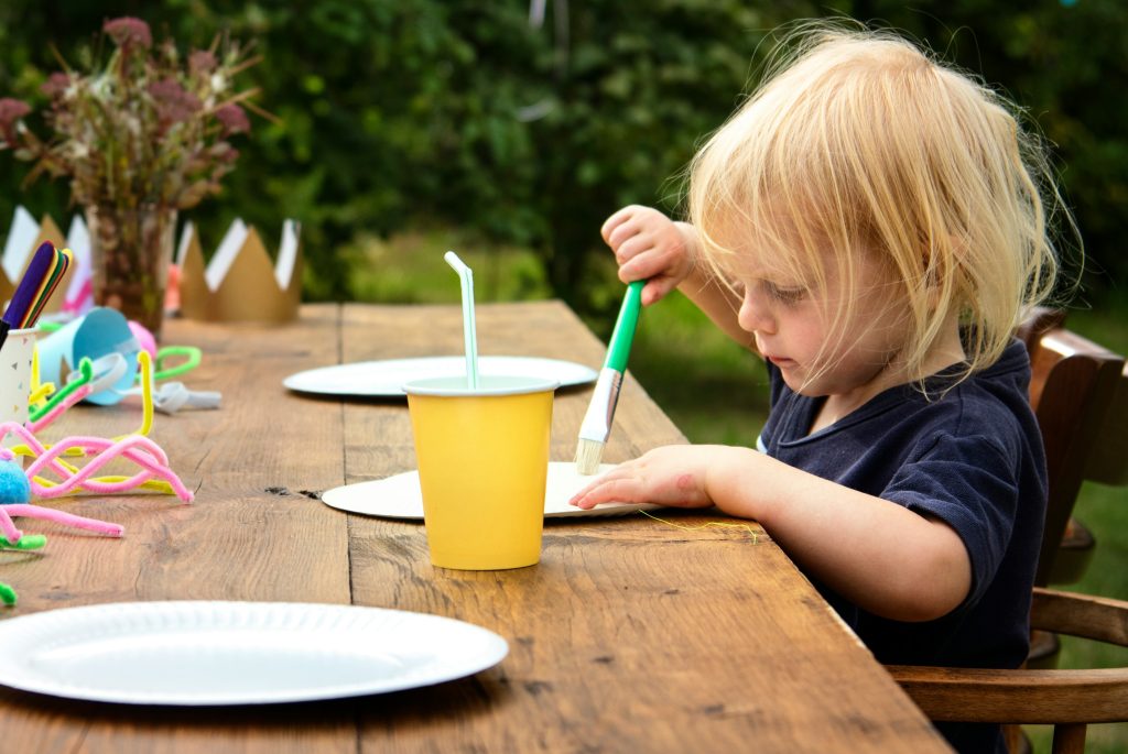 Kids' activity table with colouring books and craft supplies.